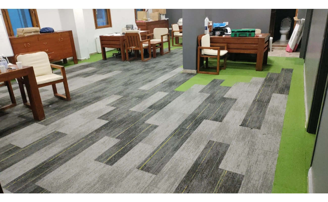 Modern ofiste gri-yeşil desenli karo halı kaplama uygulaması
